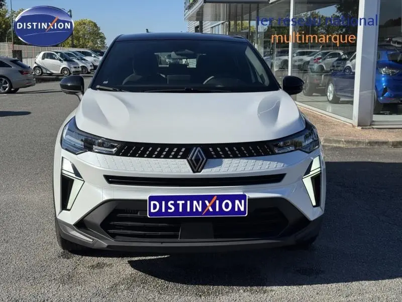 Vue de face du Renault Captur blanc nacré 2025 avec calandre moderne et logo central distinctif.