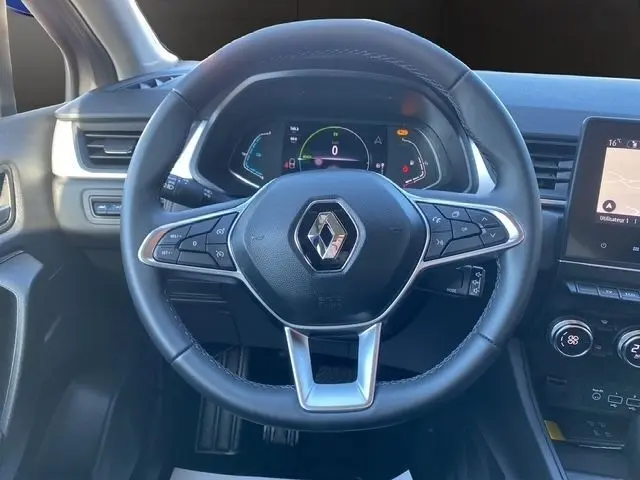 Vue rapprochée du volant en cuir synthétique multifonctions du Renault Captur gris clair, avec tableau de bord numérique en arrière-plan.