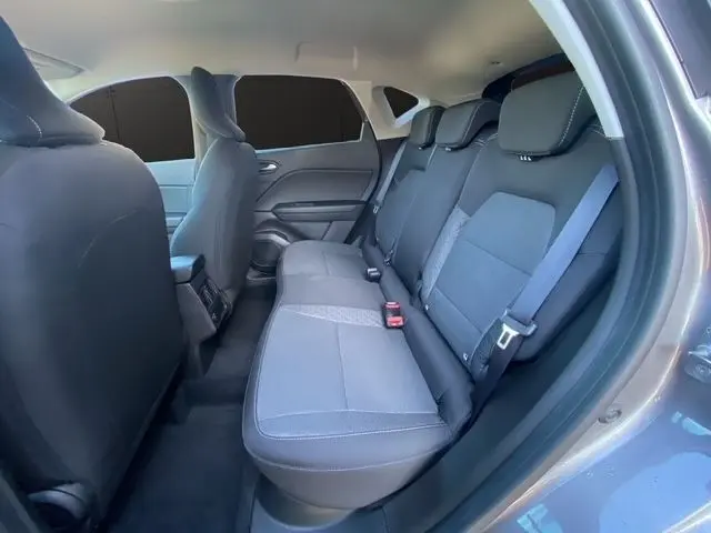 Vue intérieure côté droit montrant la banquette arrière grise du Renault Captur 2023 hybride avec ceinture de sécurité.