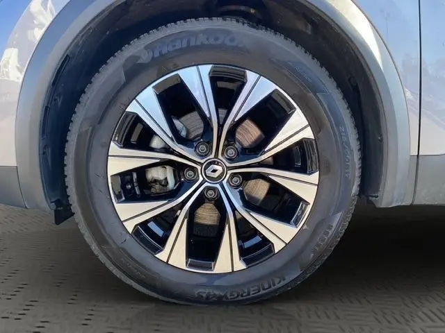 Gros plan sur la roue avant droite du Renault Captur gris clair 2023 avec jante alliage noire et argentée distinctive.