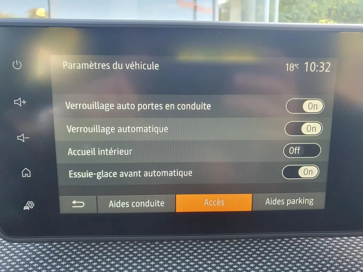 Écran tactile intérieur du tableau de bord du Dacia Sandero 2024 affichant les paramètres de verrouillage et essuie-glace automatique.