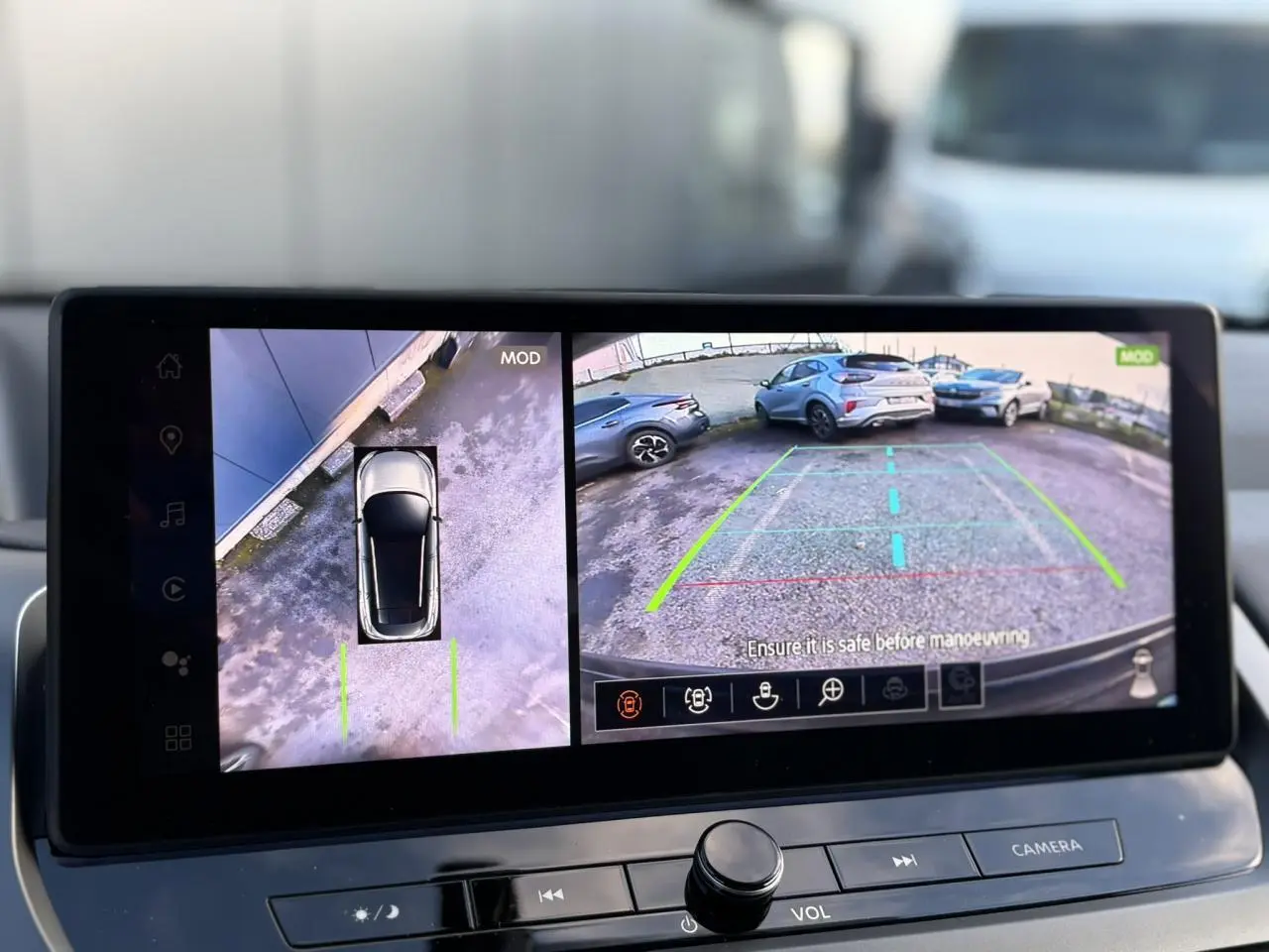 Écran intérieur affichant la caméra de recul et vue 360° du Nissan Qashqai noir Kuro en stationnement.