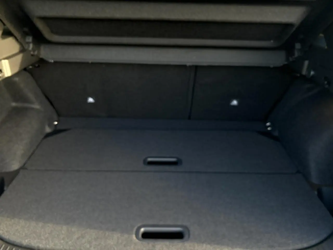 Vue intérieure du coffre du Nissan Qashqai III e-Power 2026, revêtement noir et espace de chargement plat.