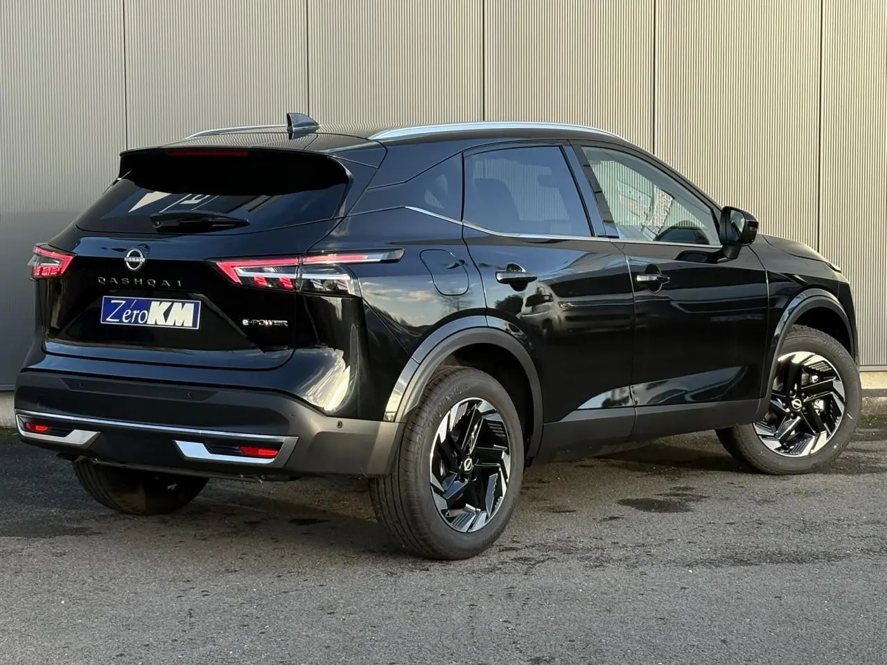 Vue 3/4 arrière droite du Nissan Qashqai III e-Power noir Kuro avec jantes alliage noires et hayon électrique fermé.