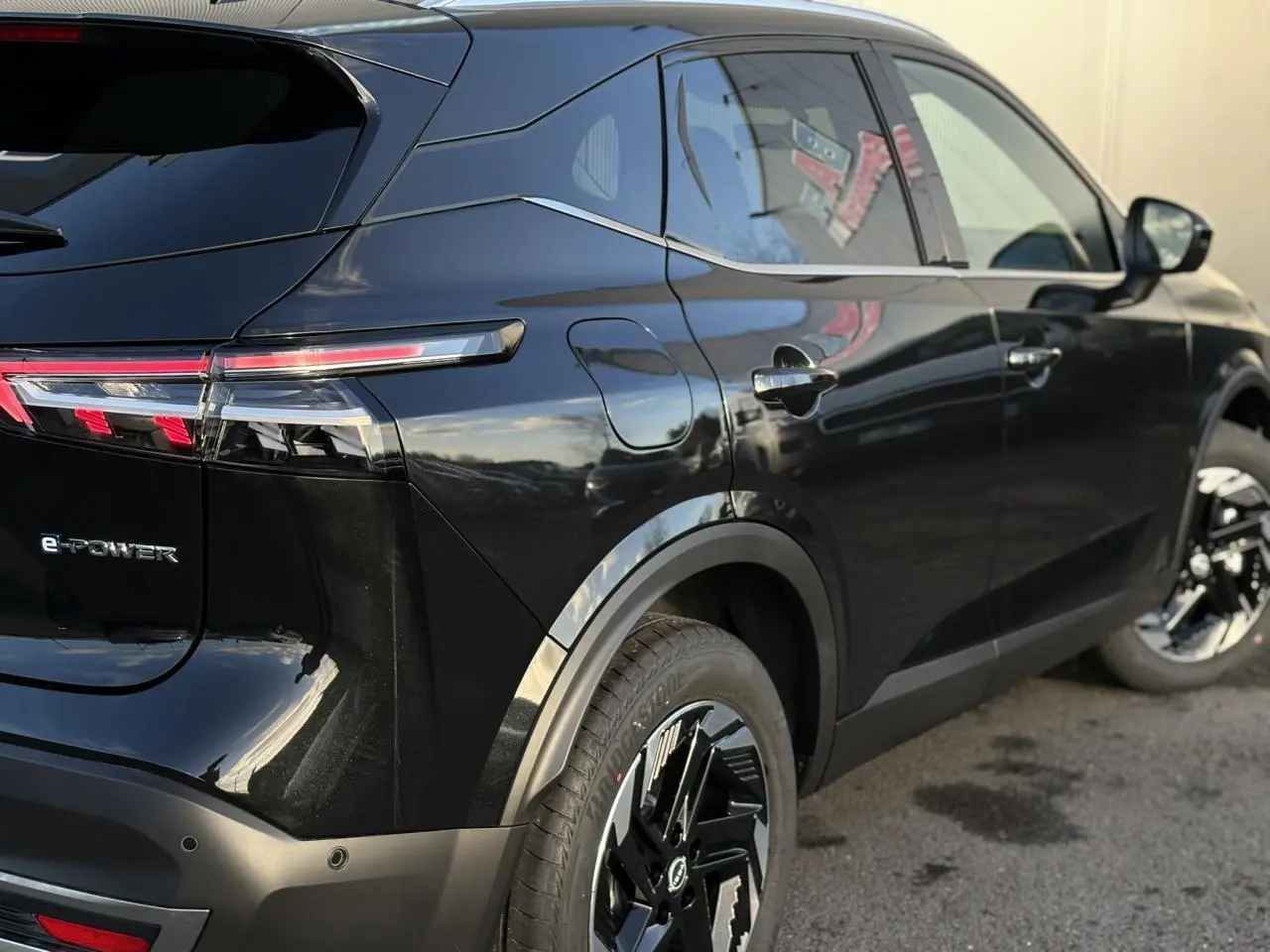 Vue 3/4 arrière droite du Nissan Qashqai III noir Kuro avec feux LED et jantes alliage noires distinctives.