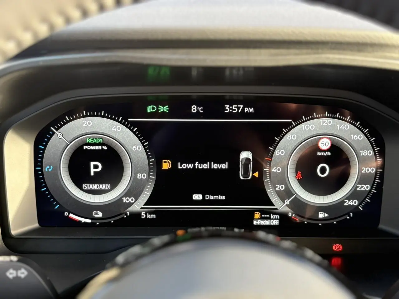 Vue rapprochée du combiné numérique du Nissan Qashqai III e-Power, affichant un avertissement de faible carburant.