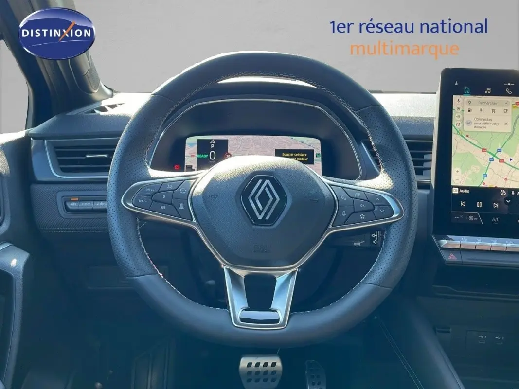 Vue intérieure centrée sur le volant cuir du Renault Captur Esprit Alpine hybride, avec tableau de bord numérique et écran tactile.