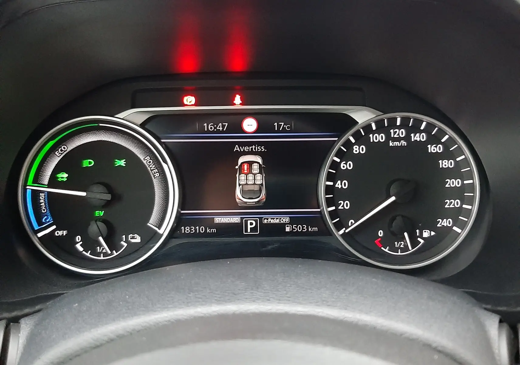 Vue rapprochée du tableau de bord numérique du Nissan Juke 2024, affichant les compteurs et alertes en cours.