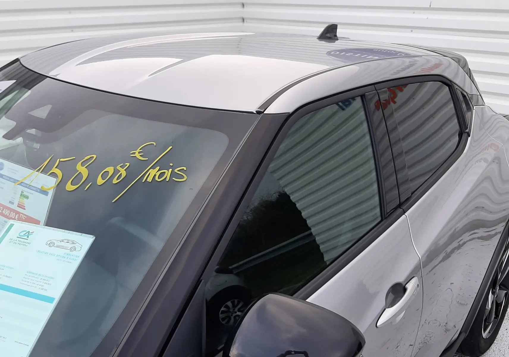 Vue 3/4 avant droit d'un Nissan Juke gris perle métal avec rétroviseur noir et vitres teintées.