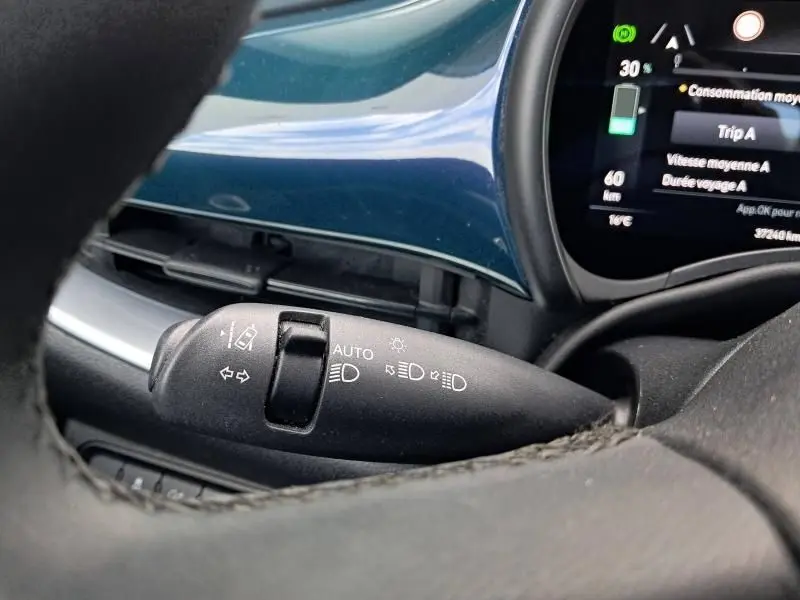 Gros plan sur la commande des feux et clignotants dans l'habitacle vert foncé métallisé d'une Fiat 500C 118 cv icone électrique 2021.