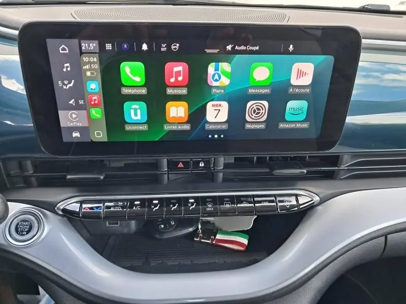 Tableau de bord de la FIAT 500C 118 cv icone 2021 vert foncé, avec écran tactile et commandes climatisation visibles.