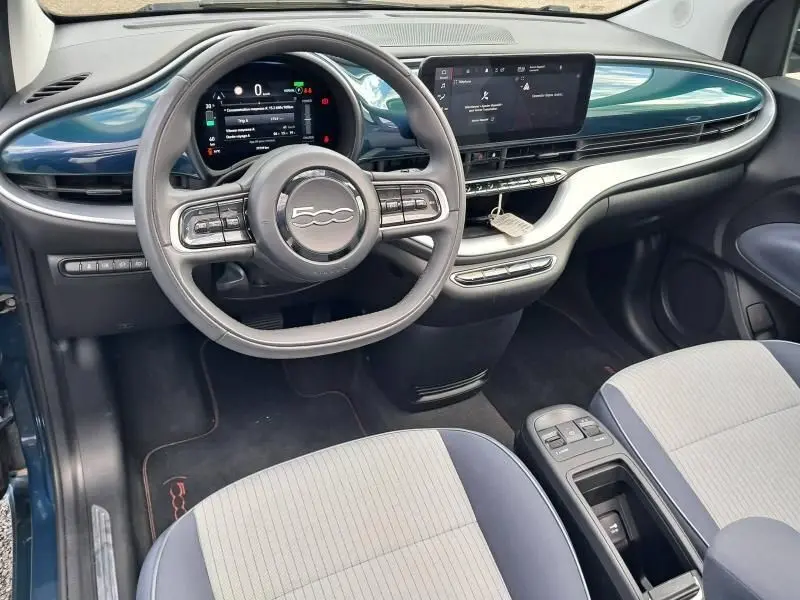 Intérieur du Fiat 500C électrique 2021, vue du poste de conduite avec tableau de bord numérique et finition bleu foncé métallisé.