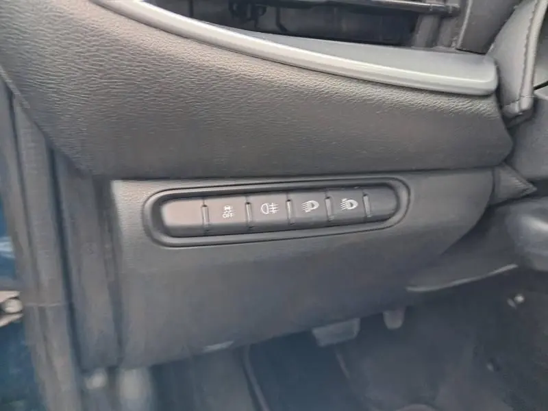 Gros plan sur les commandes d'éclairage et d'assistance du tableau de bord côté gauche d'une FIAT 500C vert foncé métal 2021.