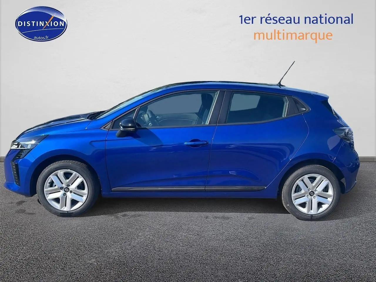 Profil côté gauche d'une Renault Clio V bleu iron 2025, avec jantes alliage et poignées ton carrosserie visibles.