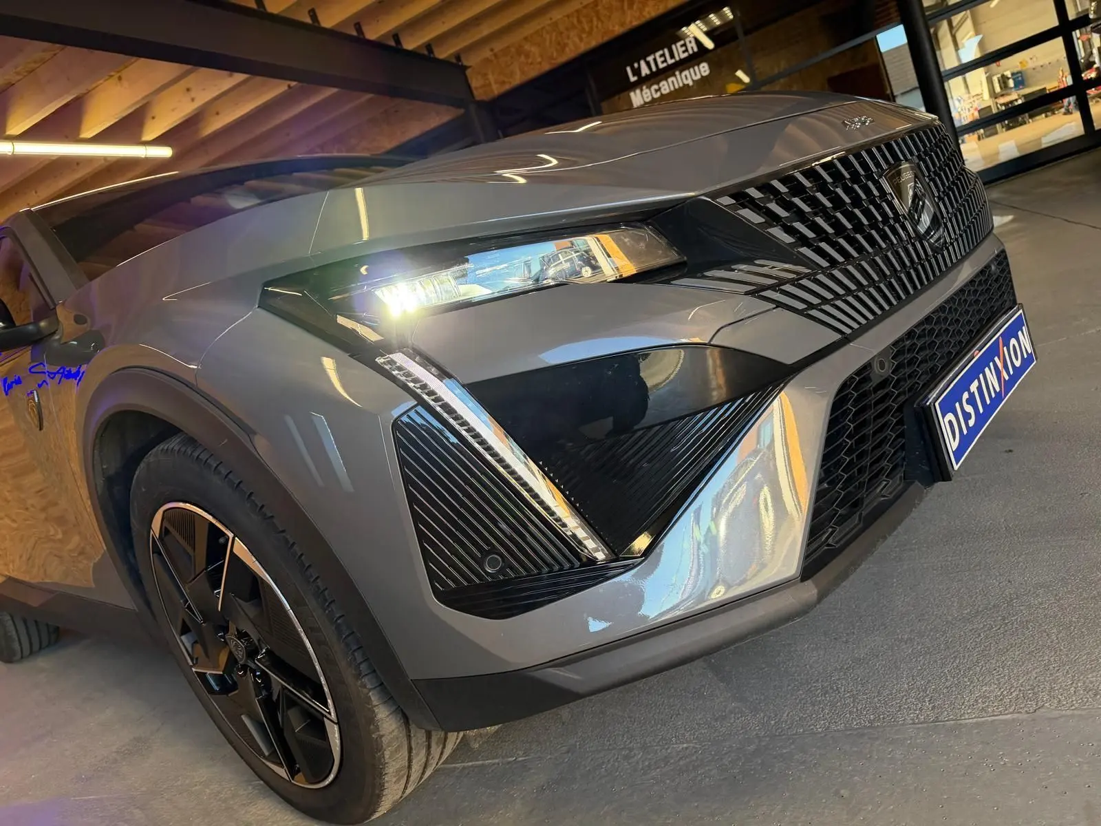 Vue 3/4 avant droit d'une Peugeot 408 gris Selenium avec calandre noire et jantes alliage 19'' diamantées.