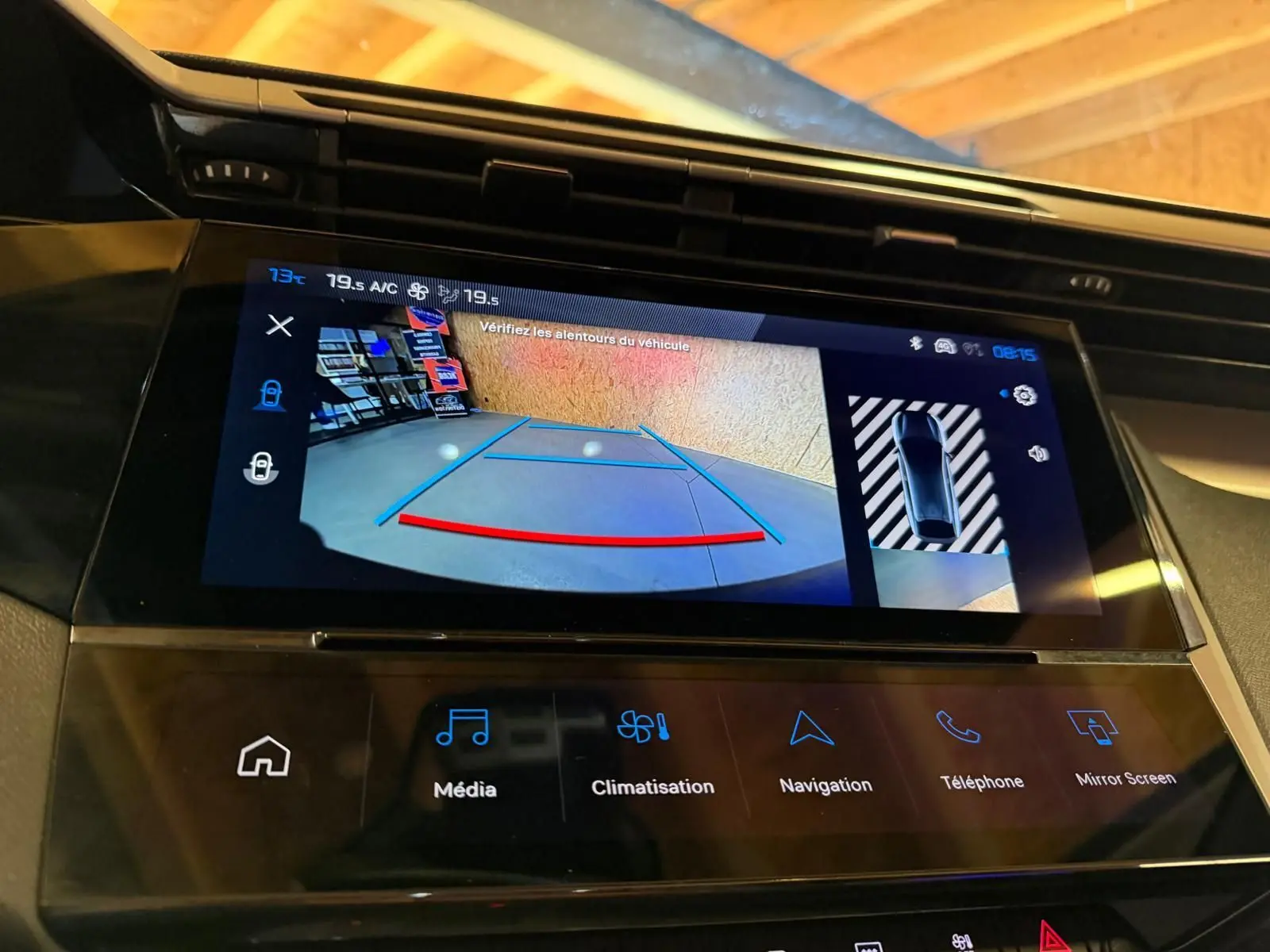 Écran tactile central de la Peugeot 408 gris, affichant la caméra de recul avec aides au stationnement.