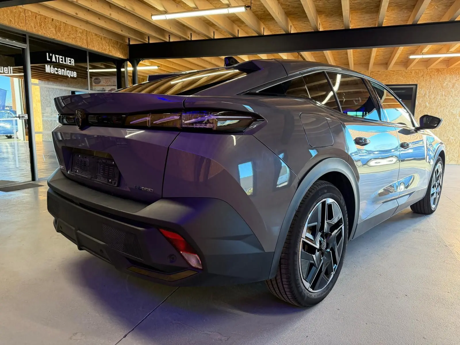 Vue 3/4 arrière droite de la Peugeot 408 gris métallisé avec jantes alliage 19'' diamantées et feux arrière LED griffés.