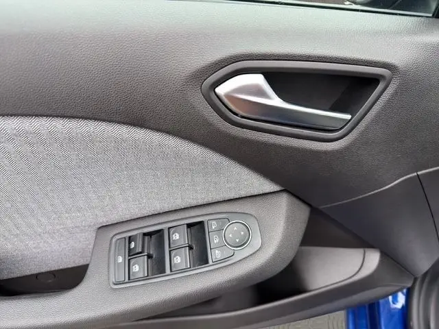 Détail de la porte côté conducteur de la Renault Clio Techno E-Tech 2025 avec commandes des vitres et poignée intérieure grise.