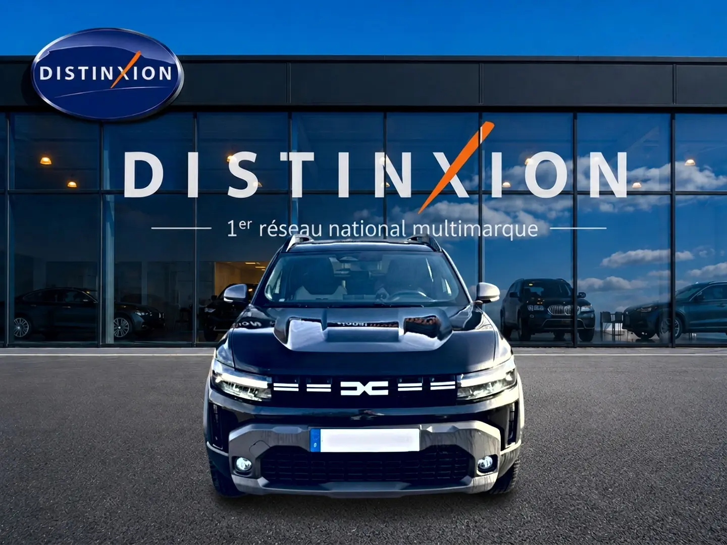 Vue avant d'un Dacia Duster 1.2 mild hybrid noir avec calandre distinctive et phares LED allumés.
