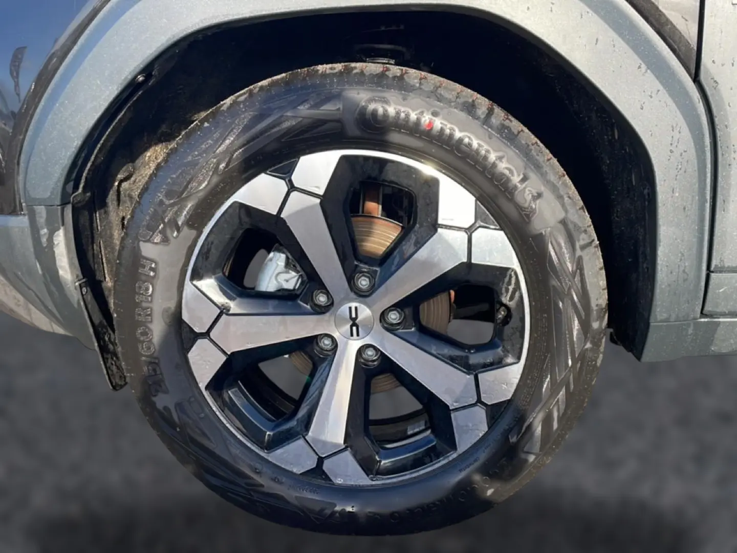 Gros plan sur la roue avant gauche du Dacia Duster noir 2026, jante alu à design géométrique bicolore.