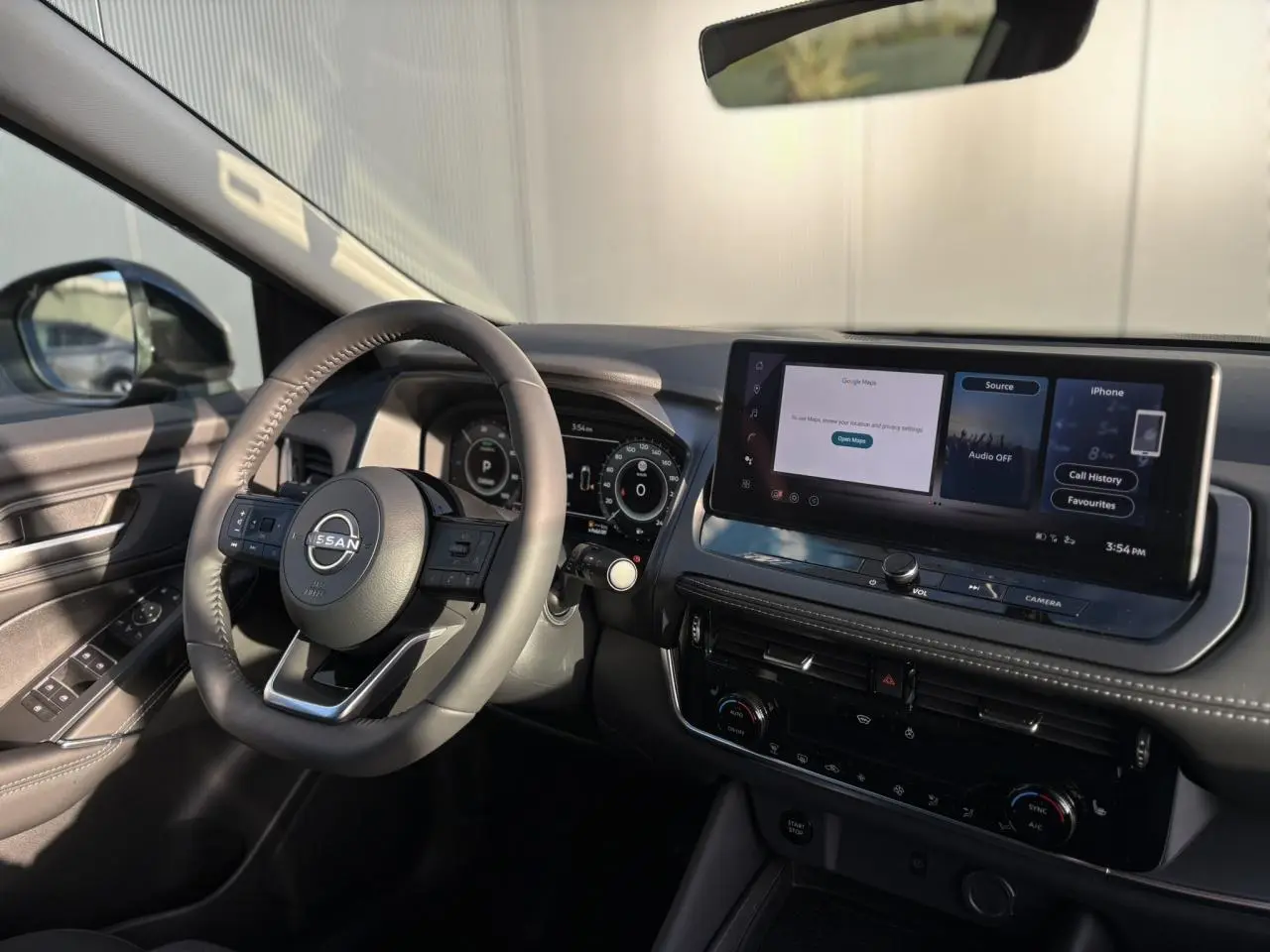 Vue intérieure côté conducteur du Nissan Qashqai III e-Power 2026, avec volant cuir et écran tactile 12,3 pouces allumé.