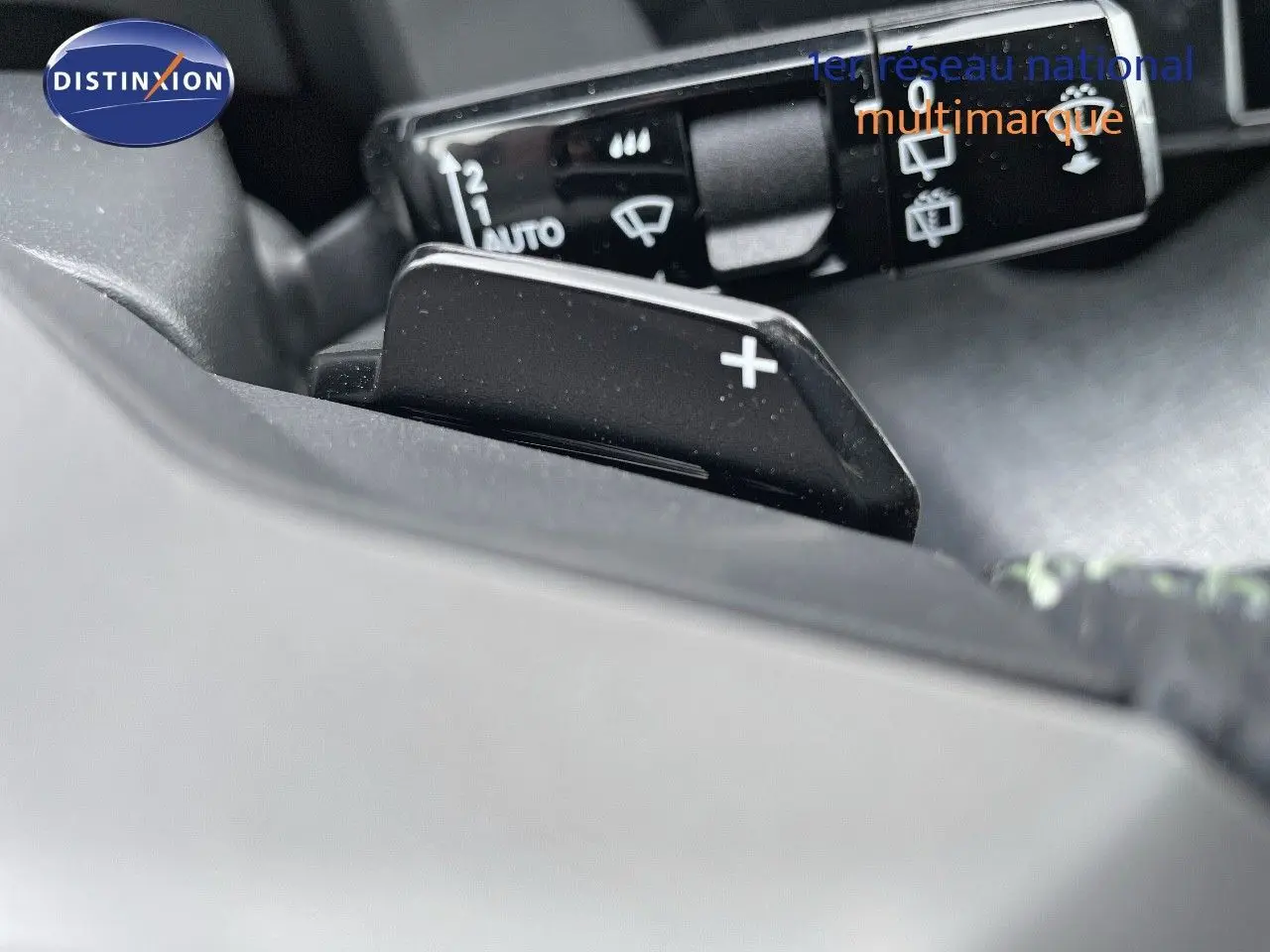 Gros plan sur la palette de changement de vitesse droite du Peugeot 5008 Hybrid 2025, intérieur gris et noir.