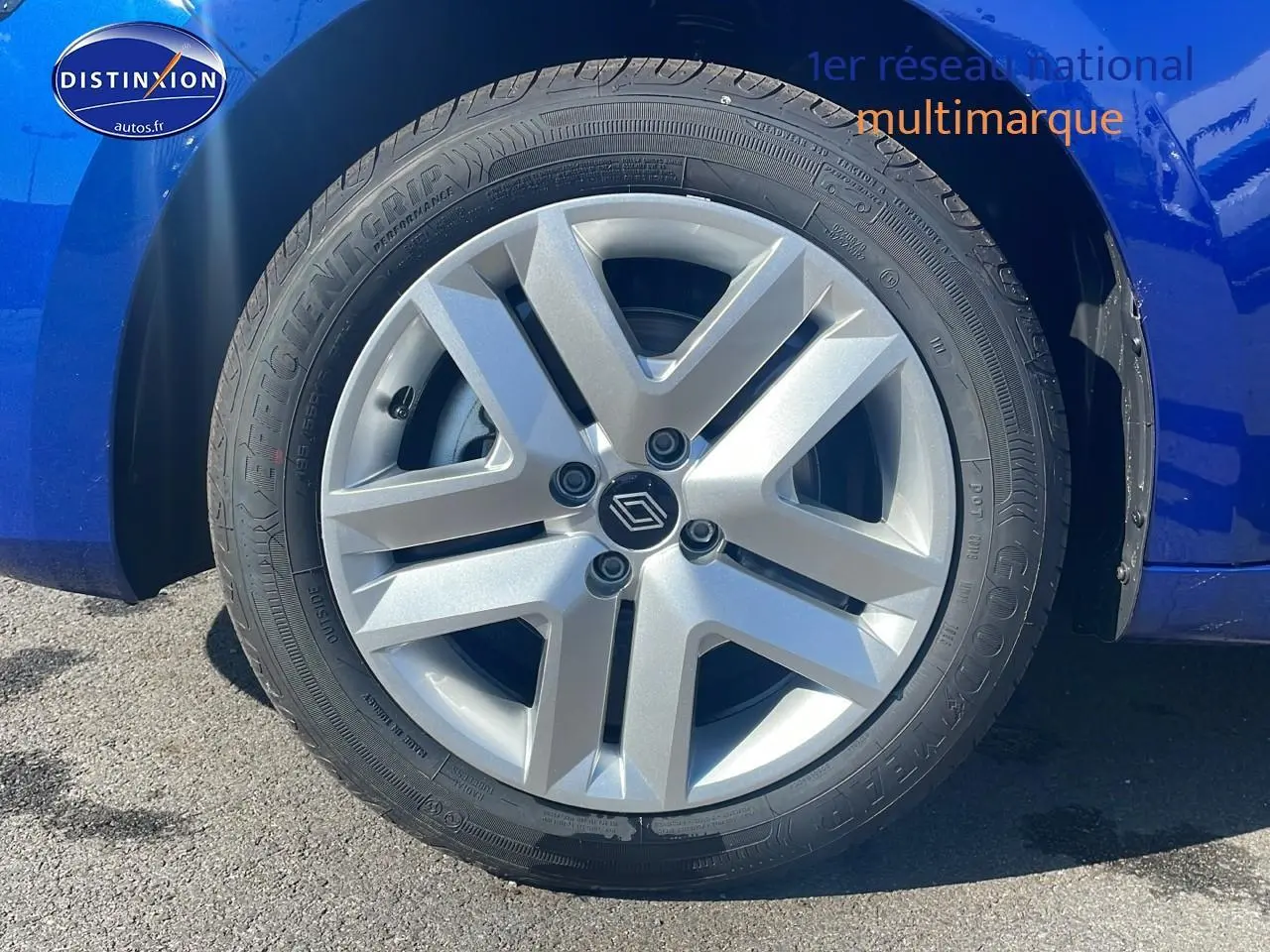 Gros plan sur la roue avant gauche avec jante argentée de la Renault Clio V bleu iron visible côté gauche.