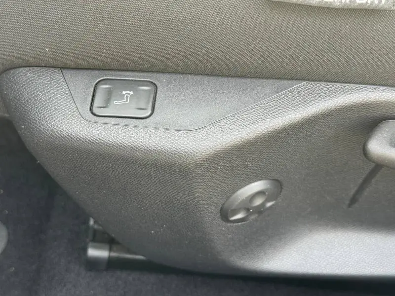 Gros plan sur le bouton de réglage électrique du siège côté conducteur du Peugeot 308 2024 en Gris Artense.