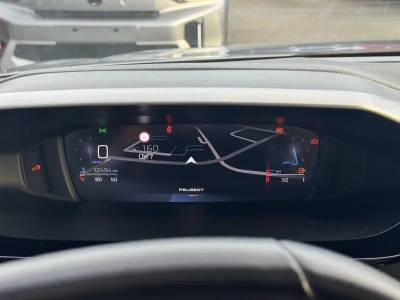 Vue rapprochée du tableau de bord numérique de la Peugeot 308 2024, affichant la navigation et les indicateurs de vitesse.