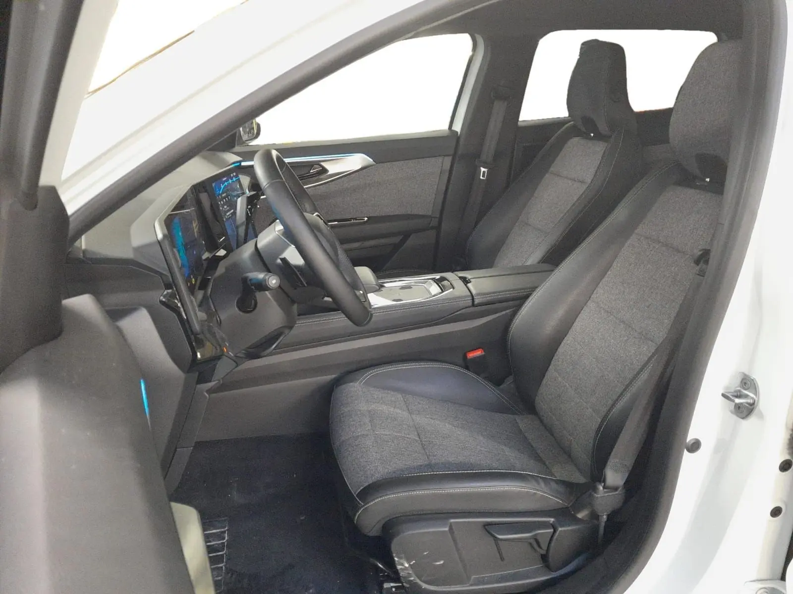 Vue intérieure côté conducteur du Renault Espace blanc nacré 2025, sièges tissu gris et tableau de bord numérique.