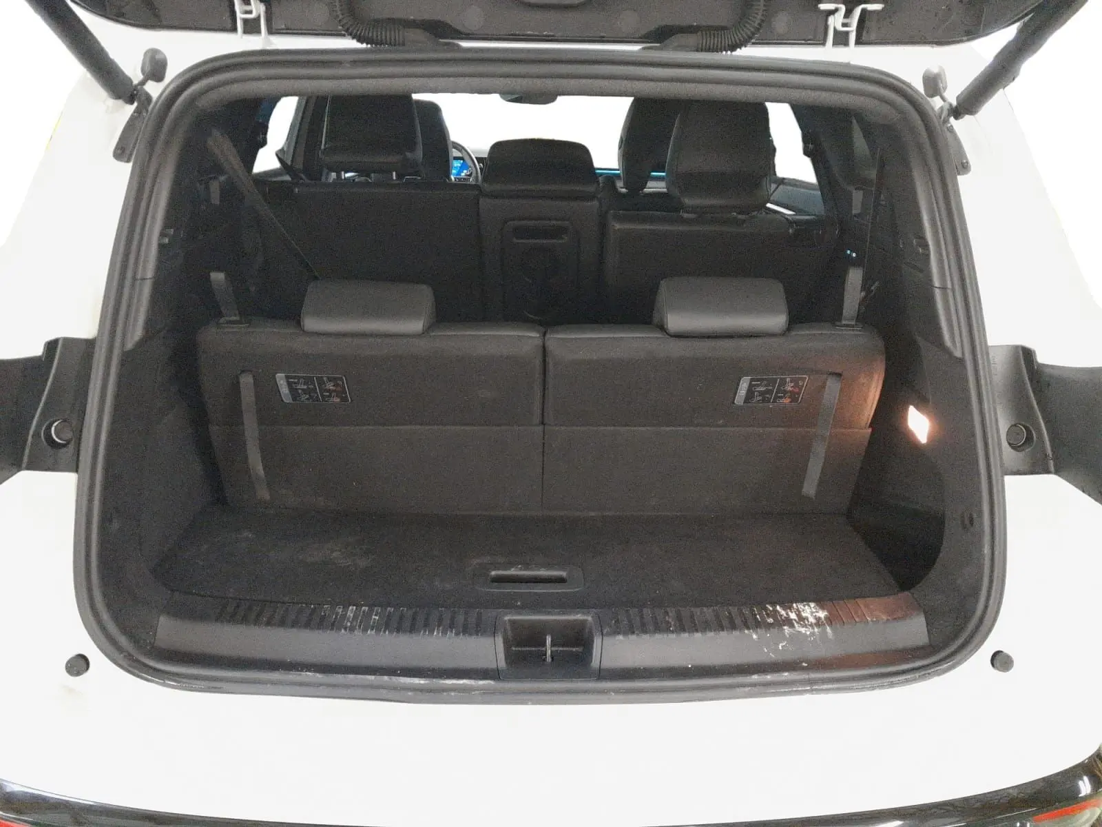 Vue arrière du coffre ouvert du Renault Espace blanc nacré, montrant la banquette arrière en position relevée.