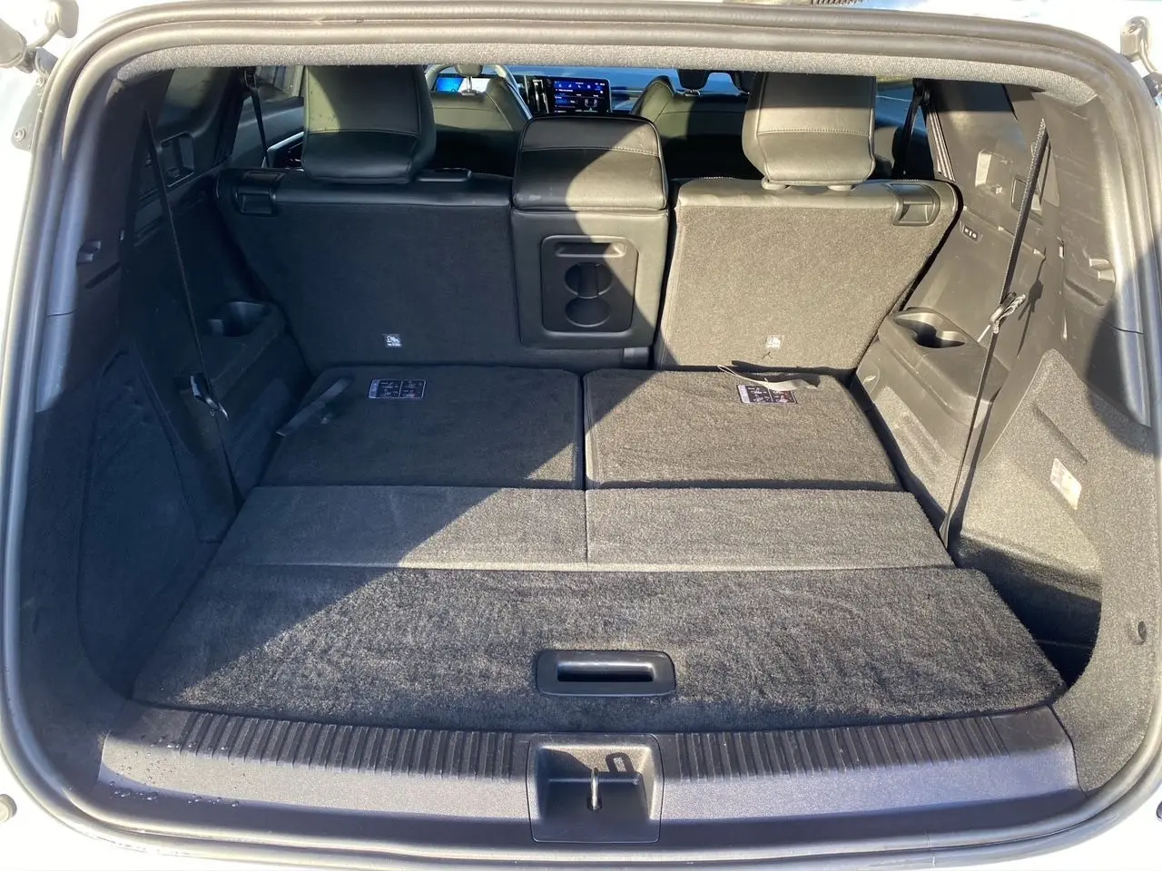 Coffre ouvert vu de l’arrière du Renault Espace 2025, banquette arrière rabattue et intérieur noir.