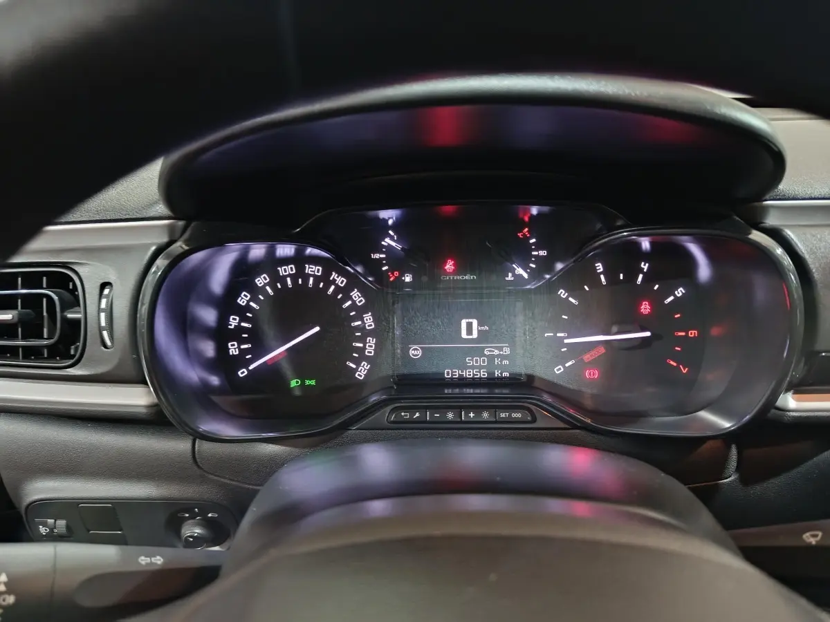 Vue rapprochée du tableau de bord de la Citroën C3 gris clair 2024, affichage numérique et compteurs analogiques éclairés.