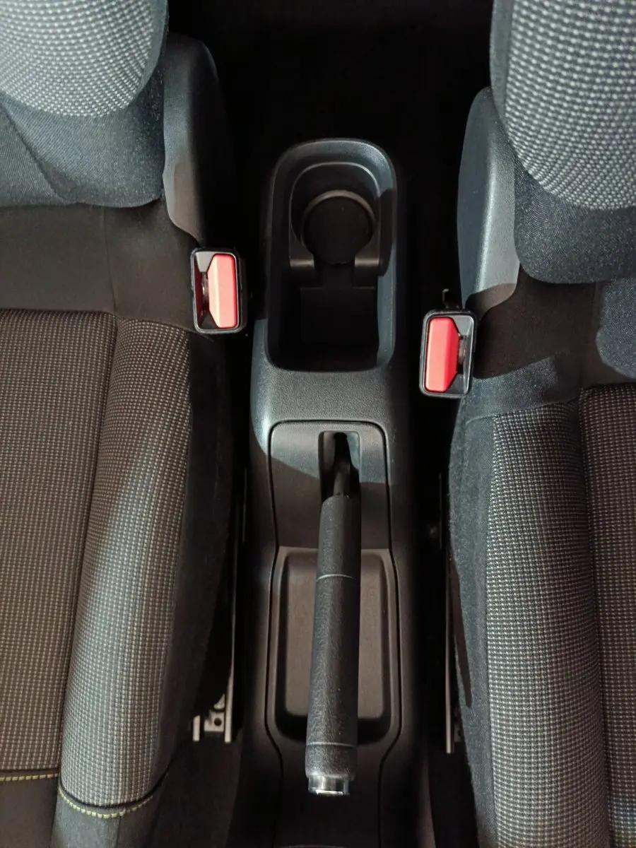 Vue plongeante sur la console centrale et frein à main entre les sièges avant gris foncé de la Citroën C3 2024.
