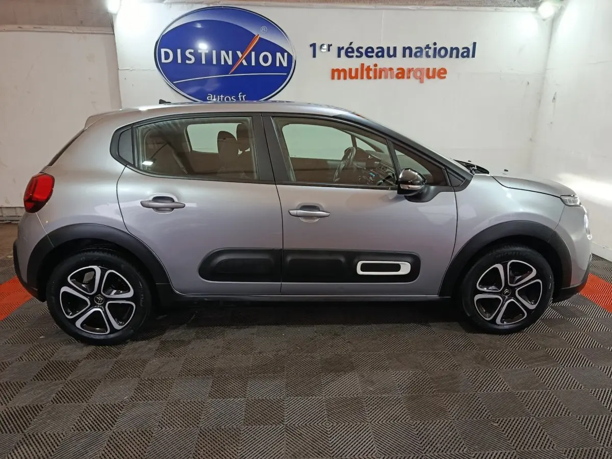 Profil droit d'une Citroën C3 2024 gris clair avec protections latérales noires et jantes alliage distinctives.