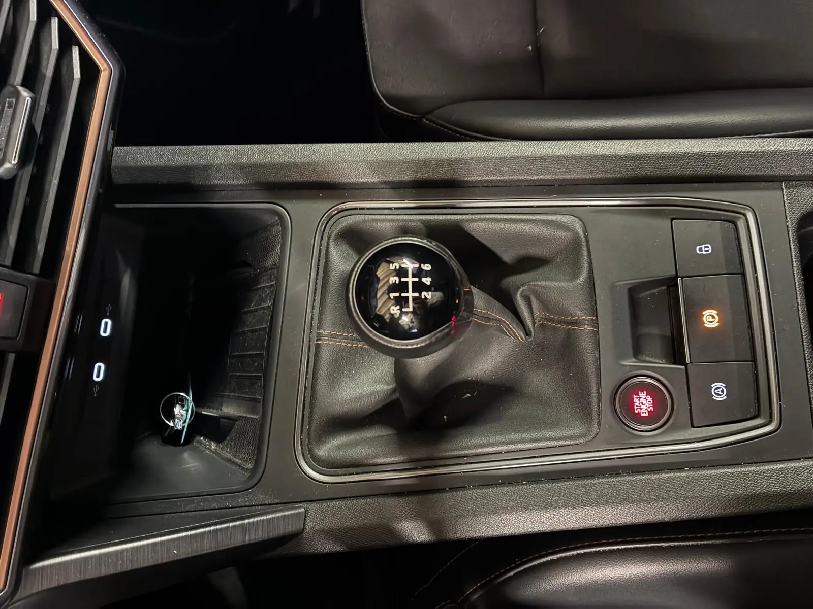 Vue plongeante sur la console centrale noire du CUPRA Formentor 2.0 TDI avec levier de vitesse manuel et bouton Start/Stop rouge.