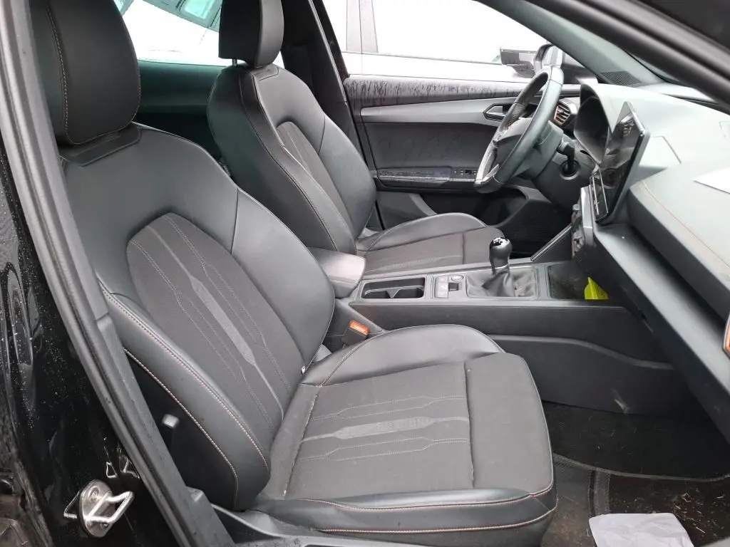 Vue intérieure côté conducteur du CUPRA Formentor 2.0 TDI noir, sièges tissu noir avec surpiqûres cuivrées et tableau de bord moderne.