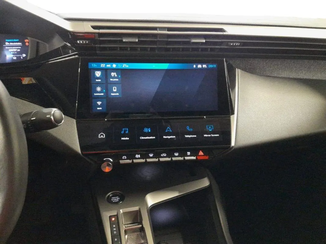 Vue intérieure centrée sur la console centrale et l’écran tactile du Peugeot 408 PHEV noir 2024, avec levier de vitesse automatique.