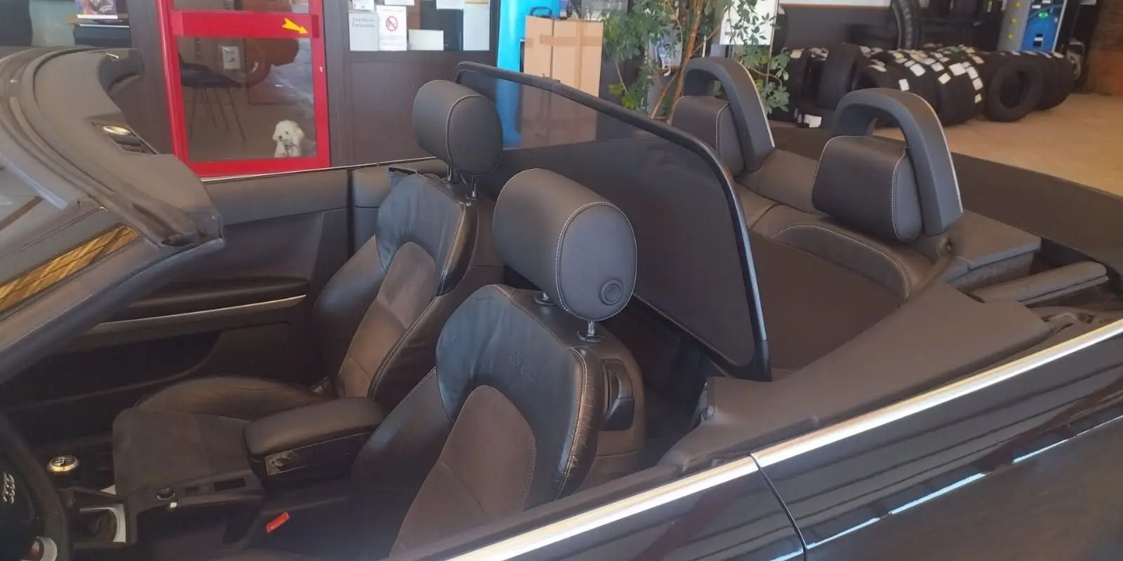 Vue intérieure côté gauche d'une Audi A3 Cabriolet noire 2010, mettant en valeur les sièges sport S-line en cuir et alcantara.