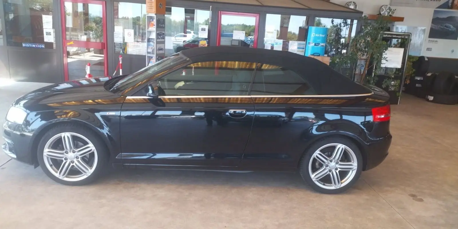 Audi A3 Cabriolet noir vue de profil côté gauche, capote fermée et jantes alliage cinq branches visibles.