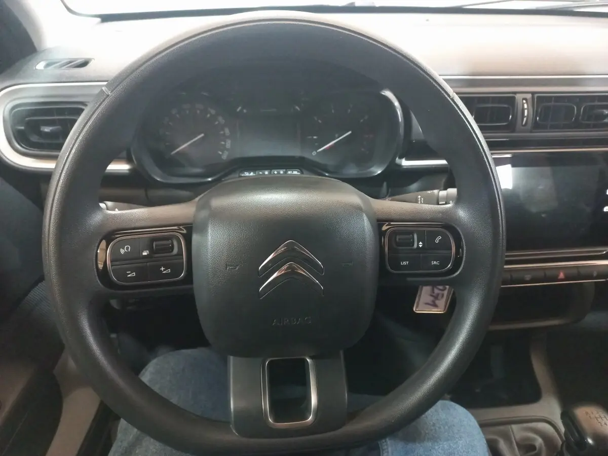 Vue rapprochée du volant noir multifonctions et du tableau de bord central tactile de la Citroën C3 2024.