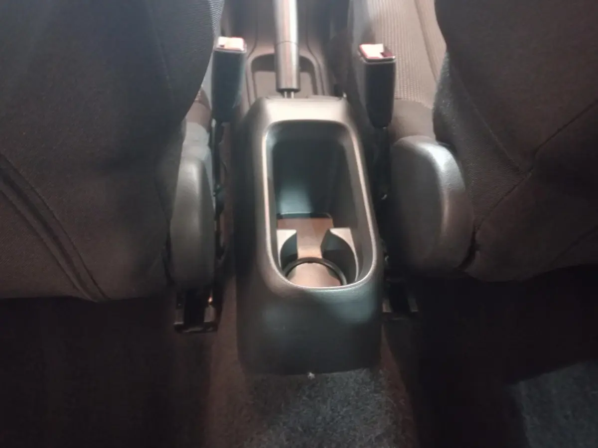 Vue rapprochée de la console centrale arrière entre les sièges noirs d'une Citroën C3 2024.