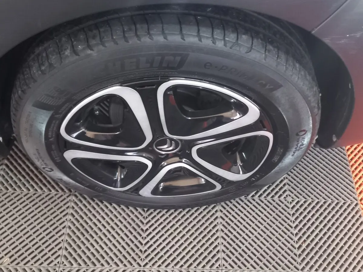 Gros plan sur la roue avant droite noire d'une Citroën C3 2024 avec jante alliage au design moderne.