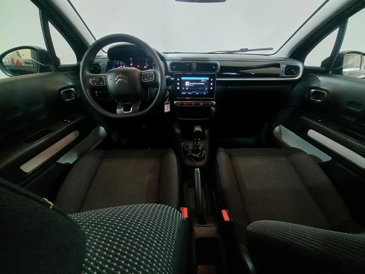 Intérieur noir de la Citroën C3 2024, vue de face sur le tableau de bord avec écran tactile et volant multifonctions.