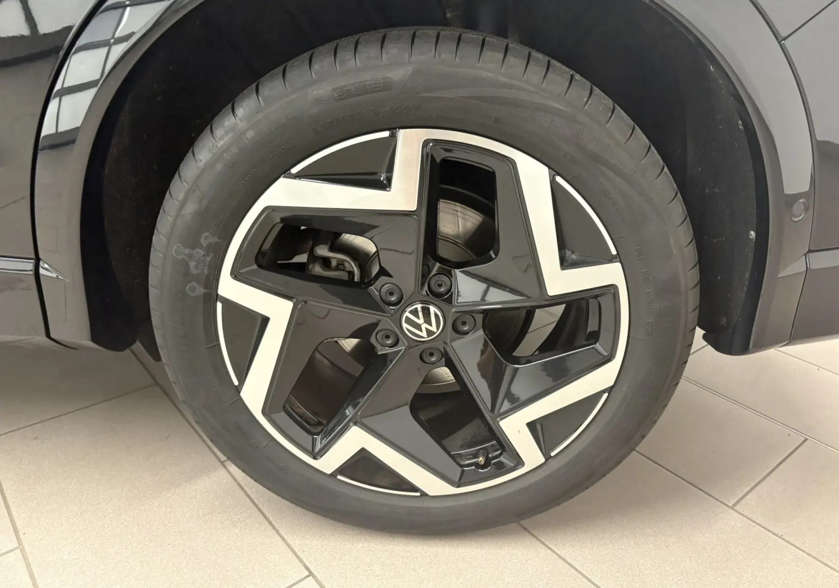 Gros plan sur la roue avant droite du Volkswagen Tiguan 2025 noir intense nacré avec jante alliage R-Line distinctive.