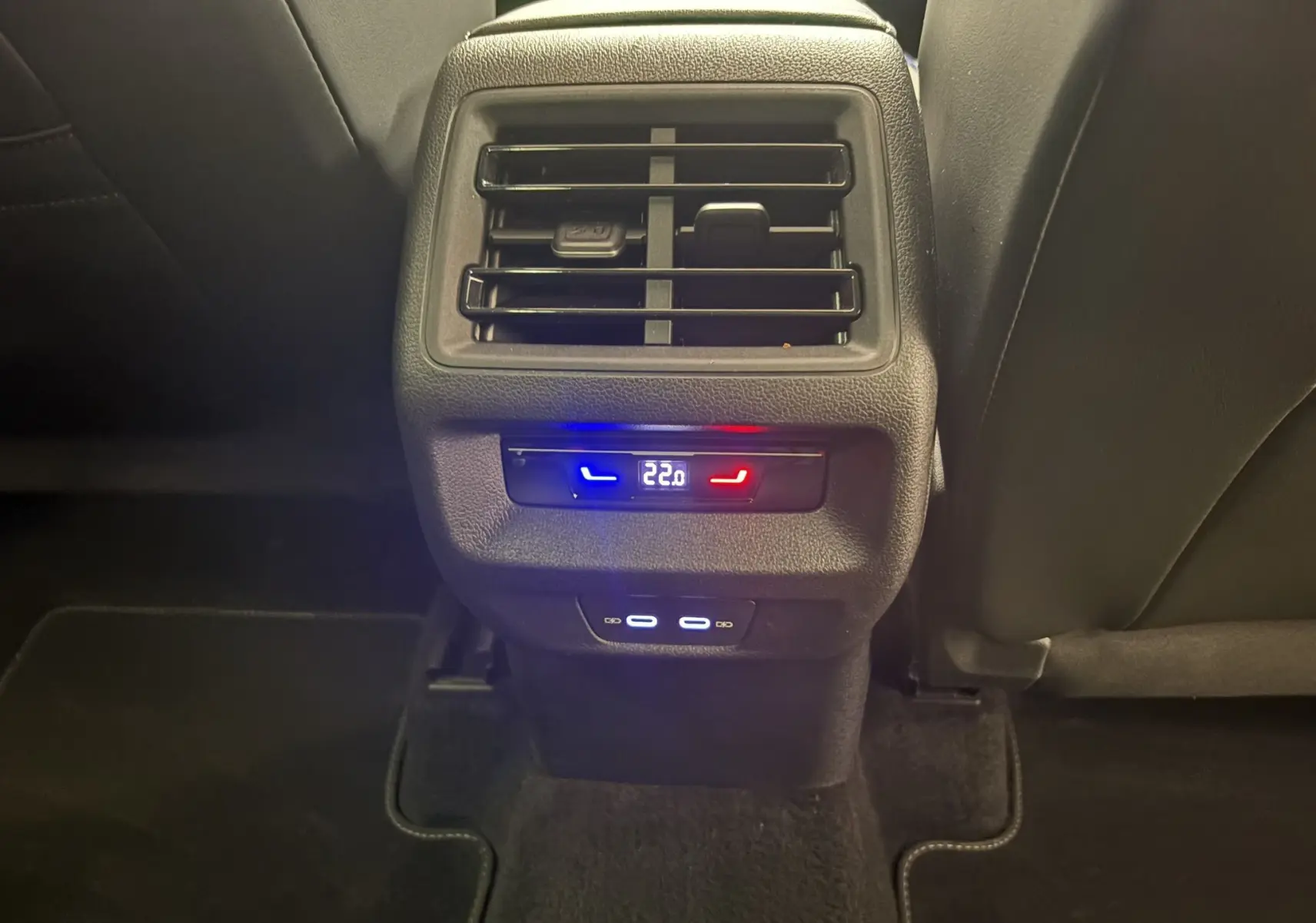 Détail de la console arrière du Volkswagen Tiguan 2025 noir intense nacré avec commandes de climatisation et ports USB visibles.