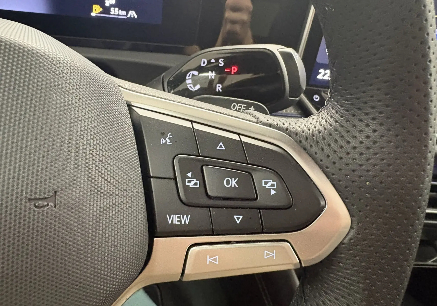 Gros plan sur les commandes multifonctions à droite du volant perforé du Volkswagen Tiguan 2025, intérieur noir.
