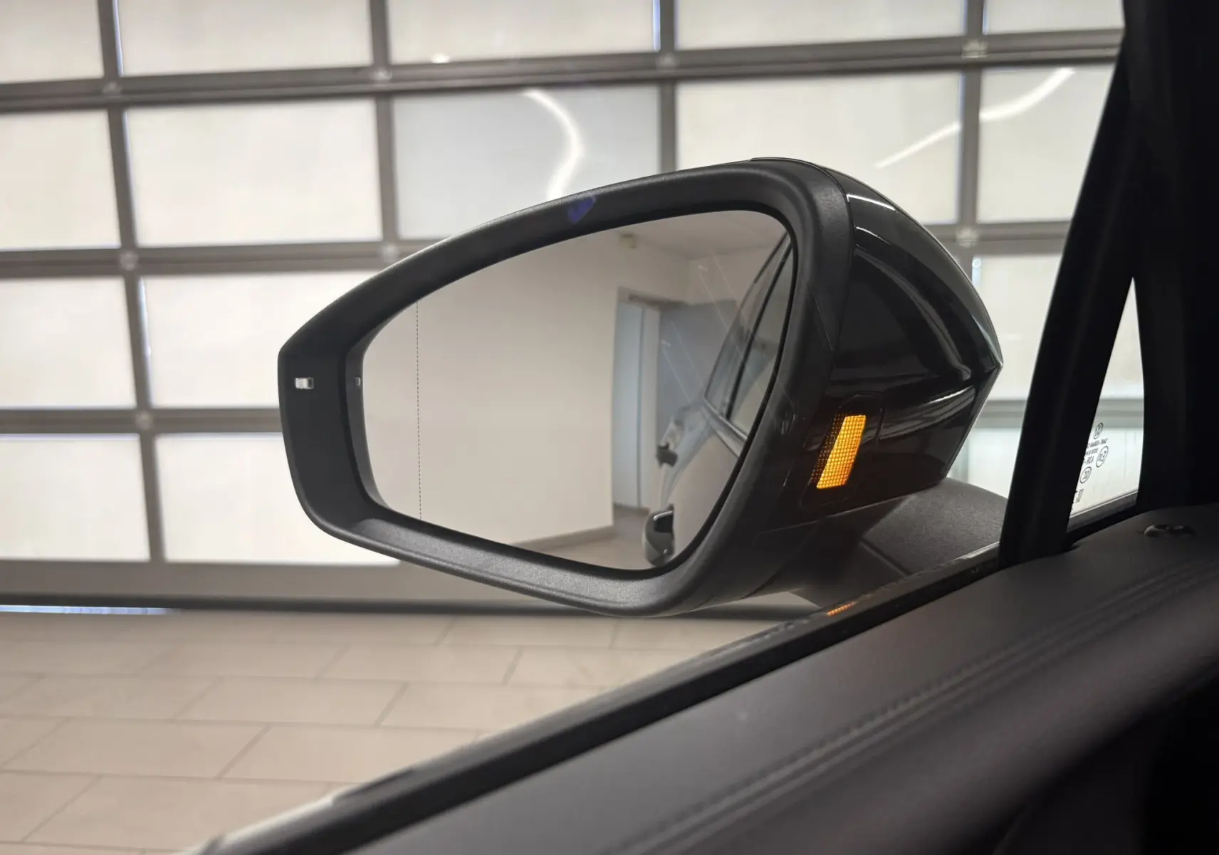 Rétroviseur côté gauche du Volkswagen Tiguan 2025 noir intense nacré avec clignotant intégré allumé.