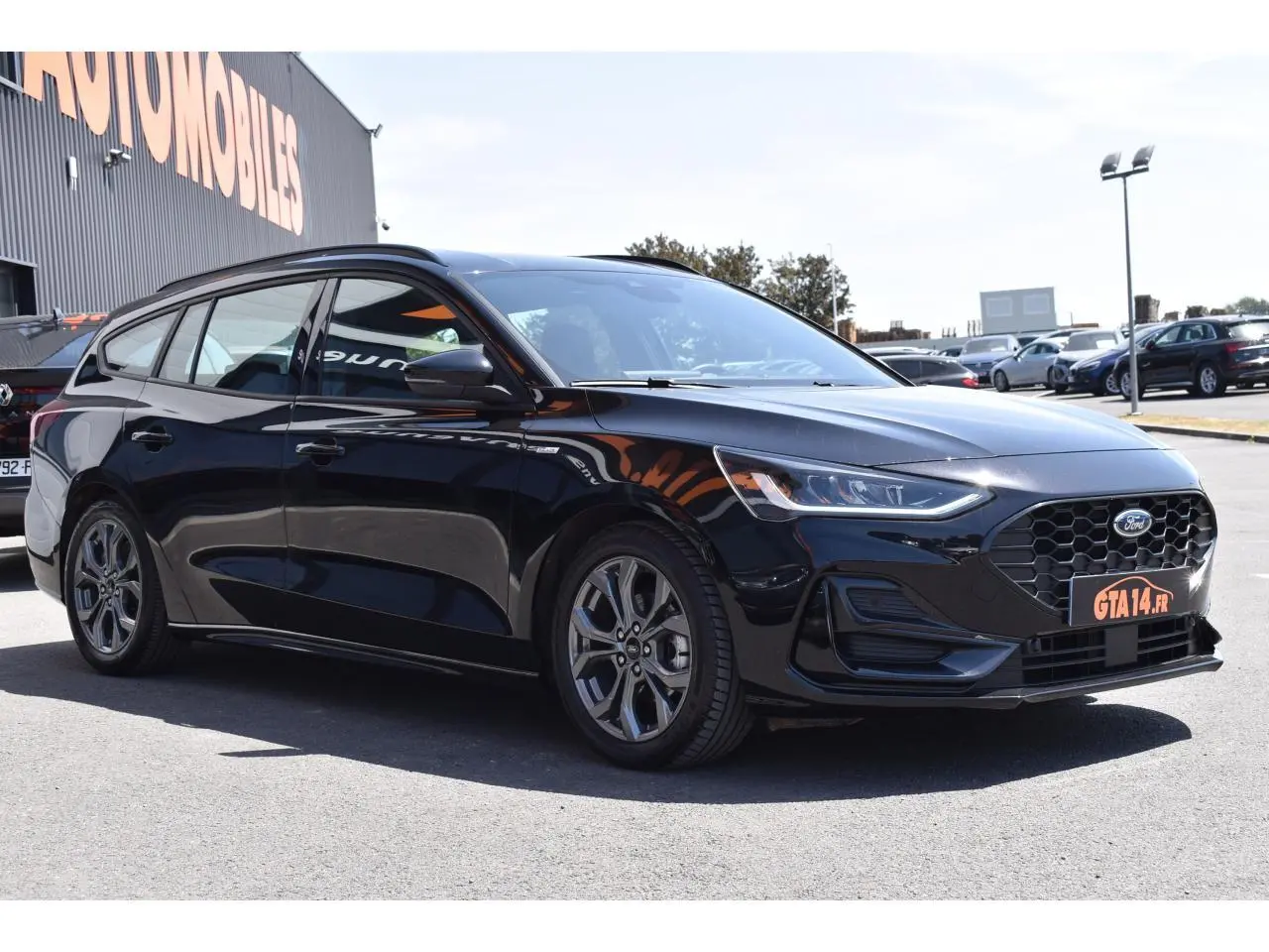 Ford Focus SW 1.5 EcoBlue 115 Powershift ST LINE X noir Agate, vue 3/4 avant droit, calandre hexagonale distinctive.
