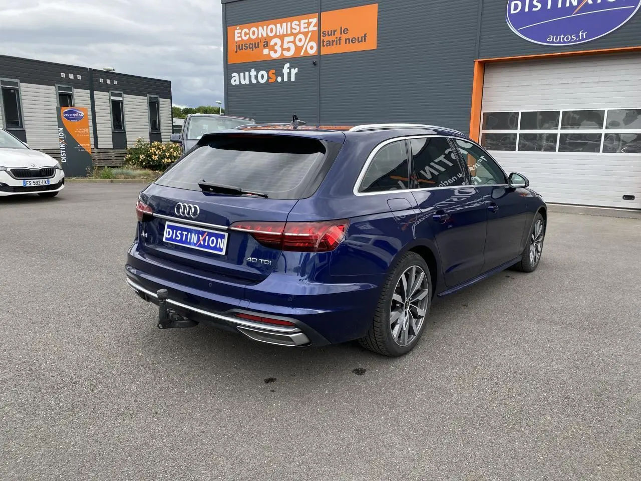 Audi A4 Avant bleu Navarre en 3/4 arrière droit, avec crochet d'attelage et jantes 18 pouces gris contrasté.